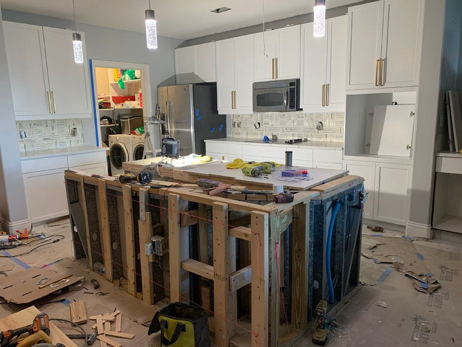 A kitchen under construction with a large island in the middle of the room.