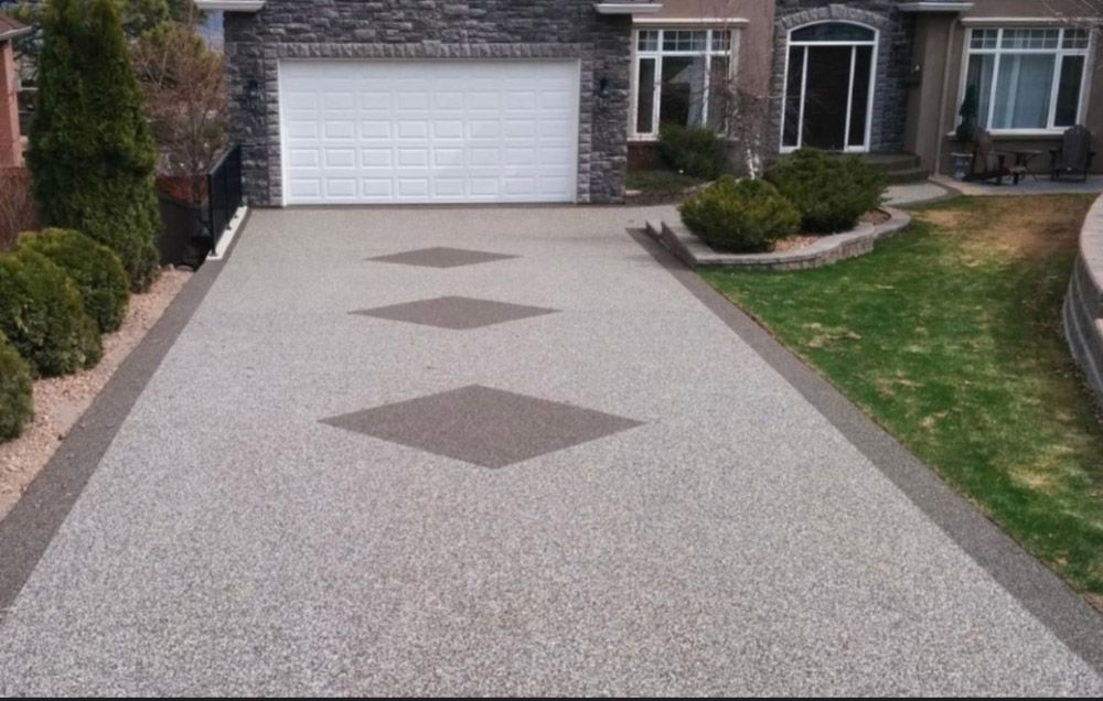 A driveway leading to a house with a garage door.