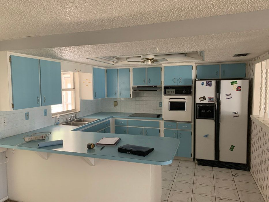A kitchen with blue cabinets and a white refrigerator