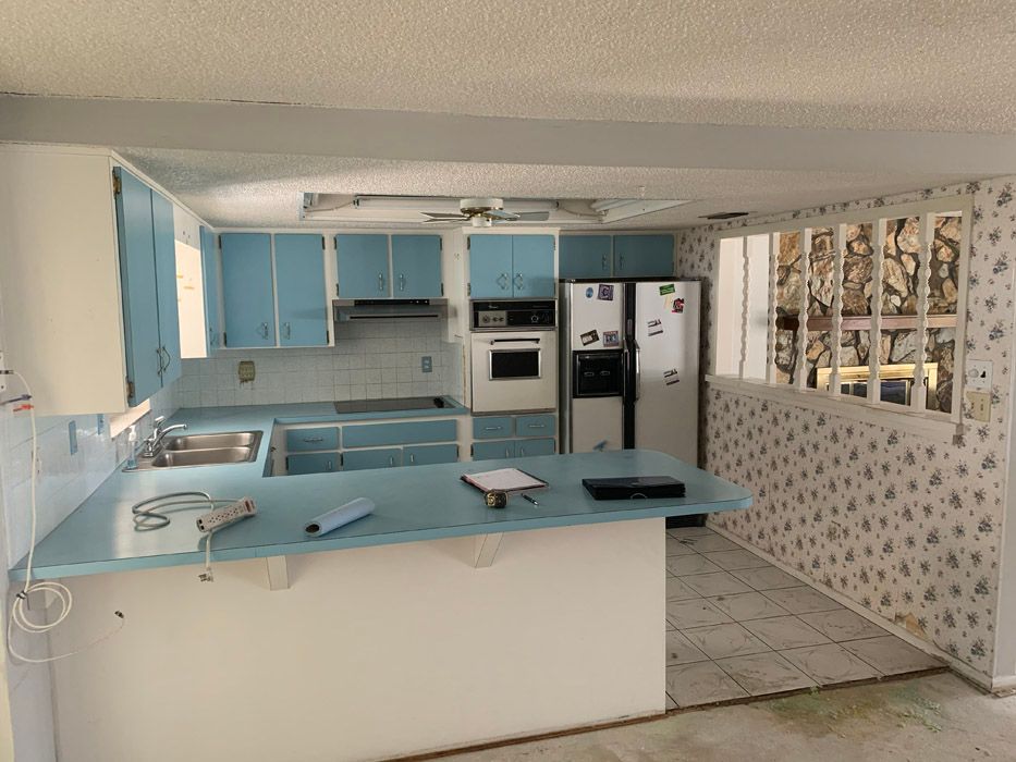 A kitchen with blue cabinets and a white refrigerator.
