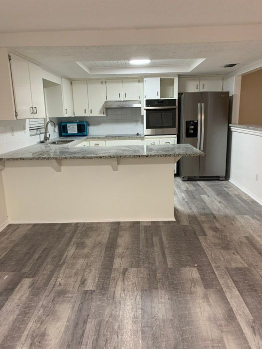 A kitchen with a refrigerator , sink , and microwave.