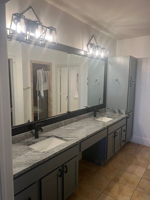 A bathroom with two sinks and a large mirror.