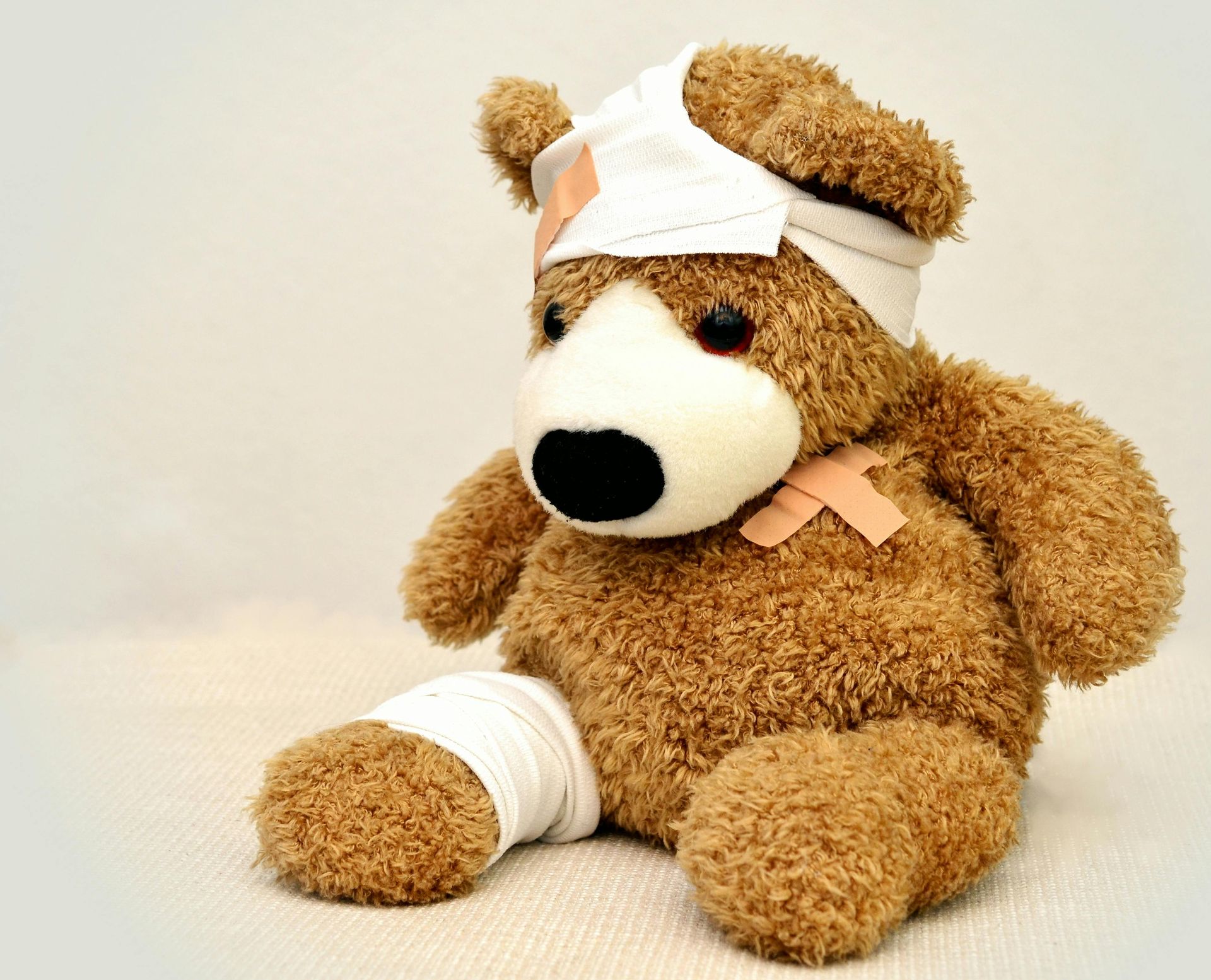 A bandaged teddy bear is sitting on a table