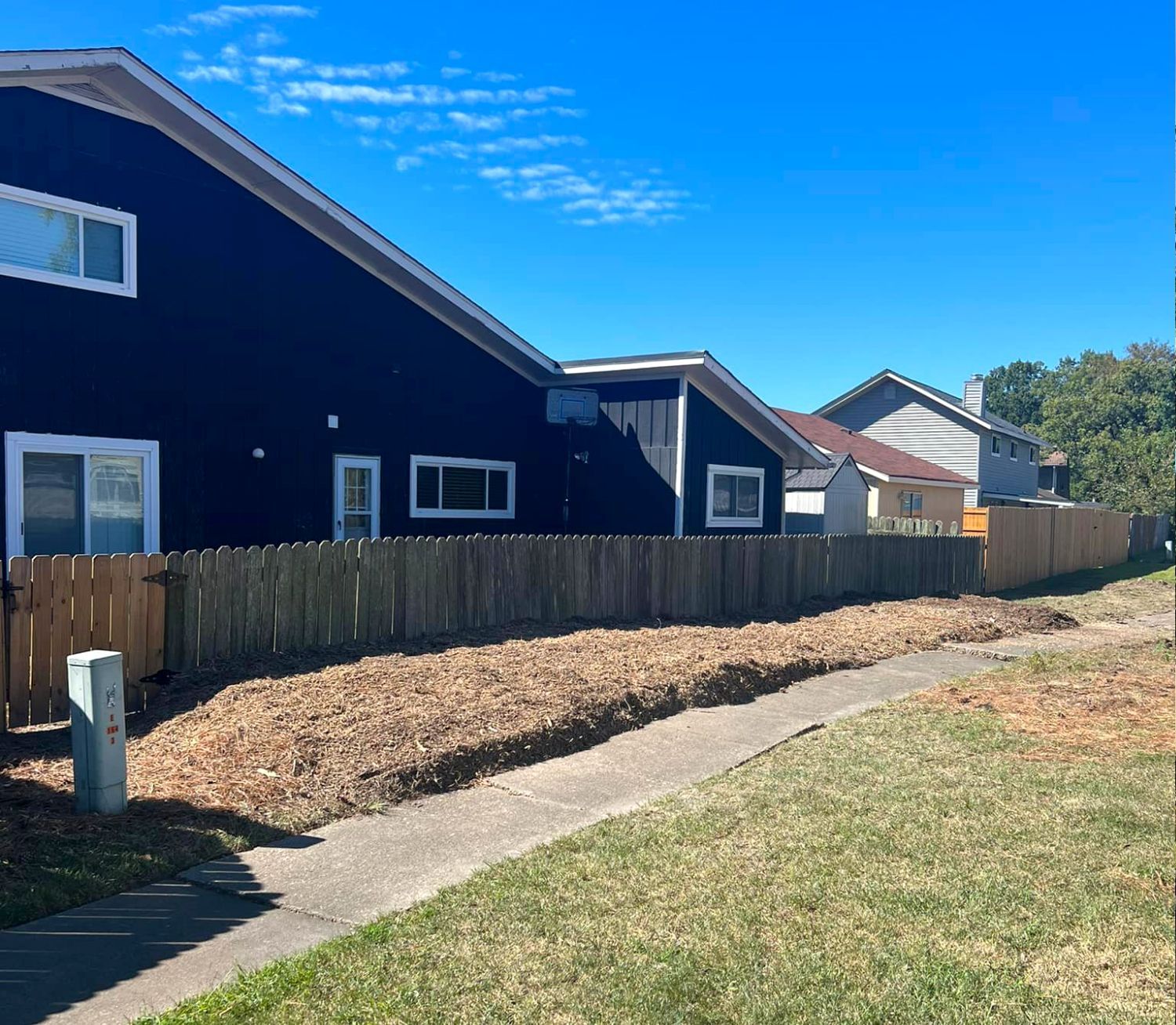 A row of houses with a wooden fence in front of them