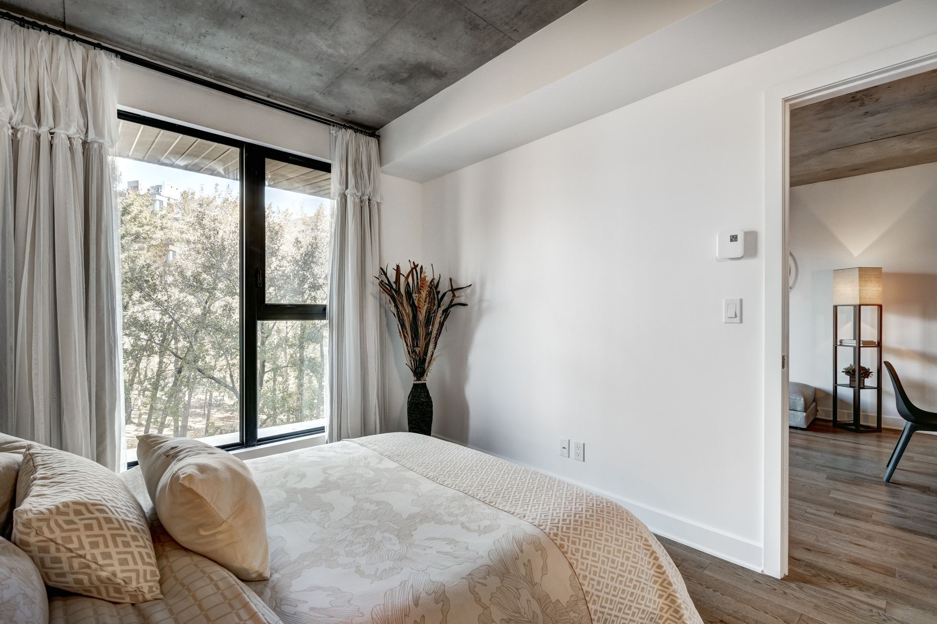 a bedroom with a large bed and a large window .