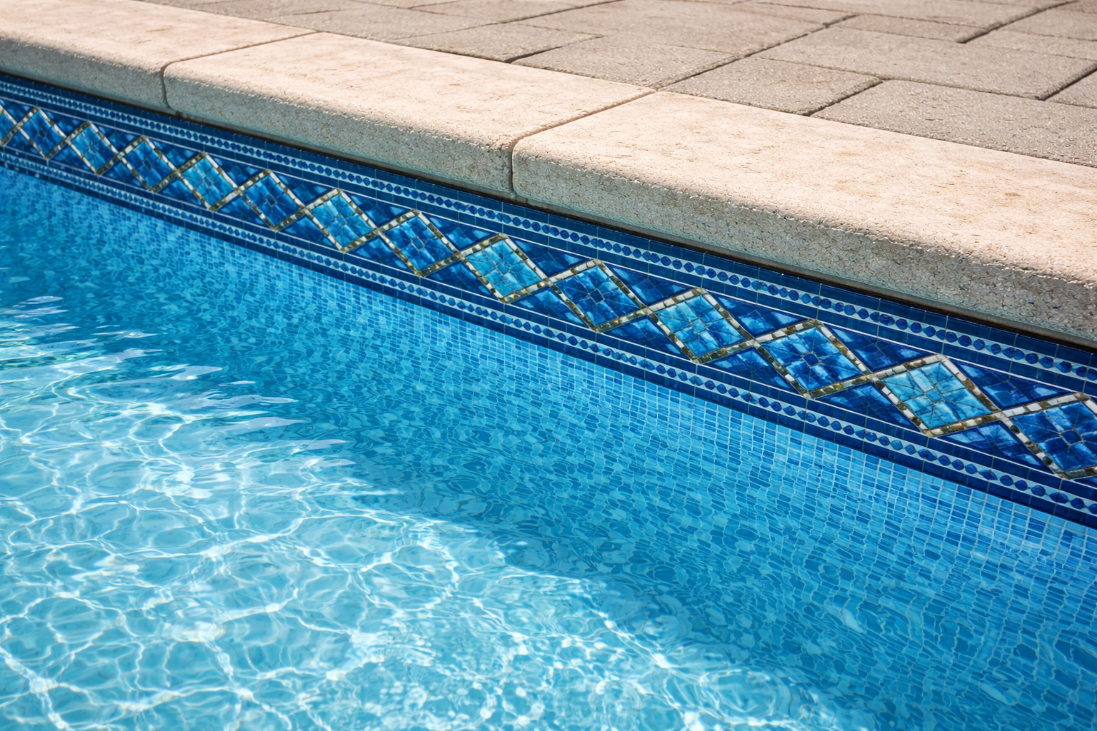 Pool edge with blue patterned tile border and clear water.