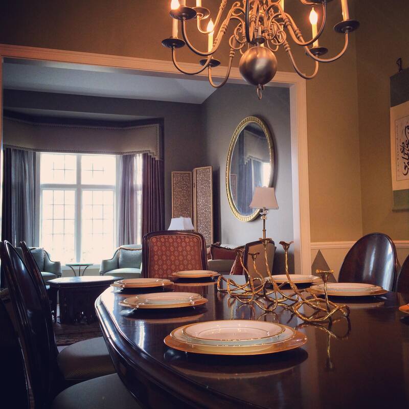 A dining room table with plates and a chandelier