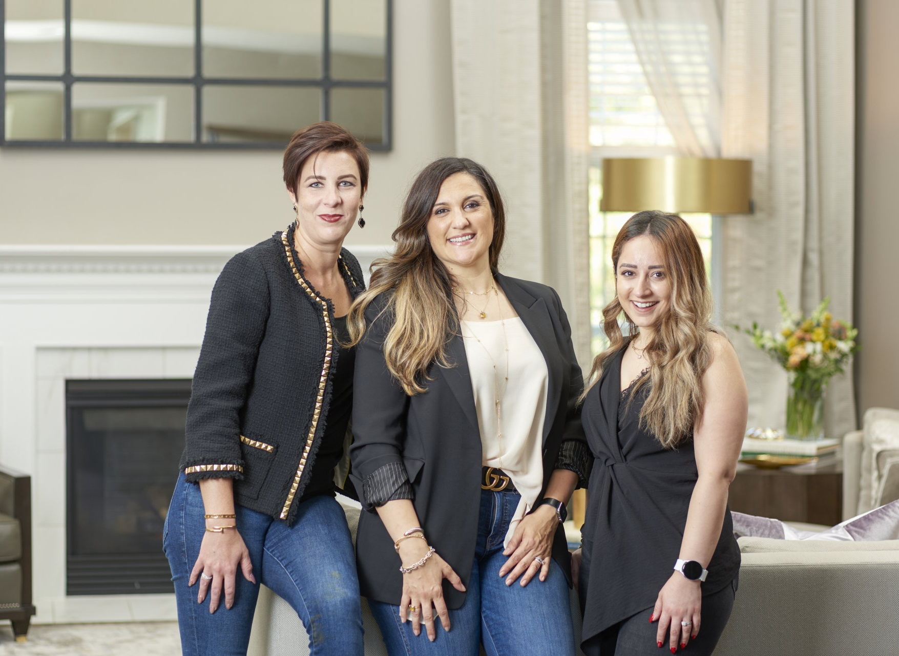 Three women are posing for a picture in a living room.