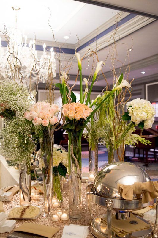 A table is decorated with vases of flowers and candles.