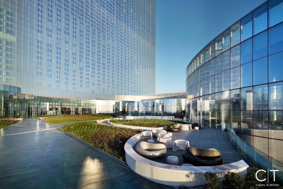 A large building with a lot of windows and a patio in front of it.