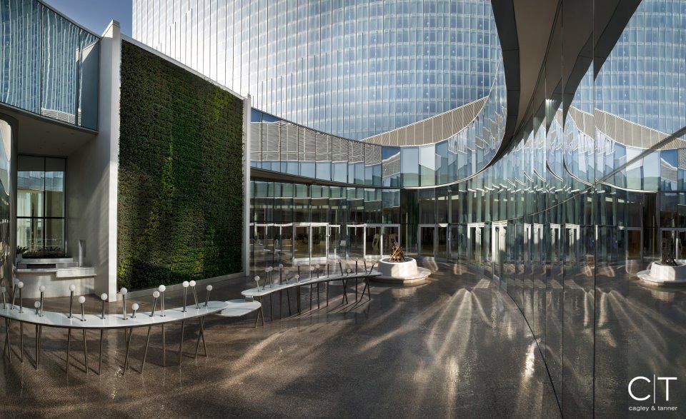 An artist 's impression of a large building with tables and chairs in front of it.