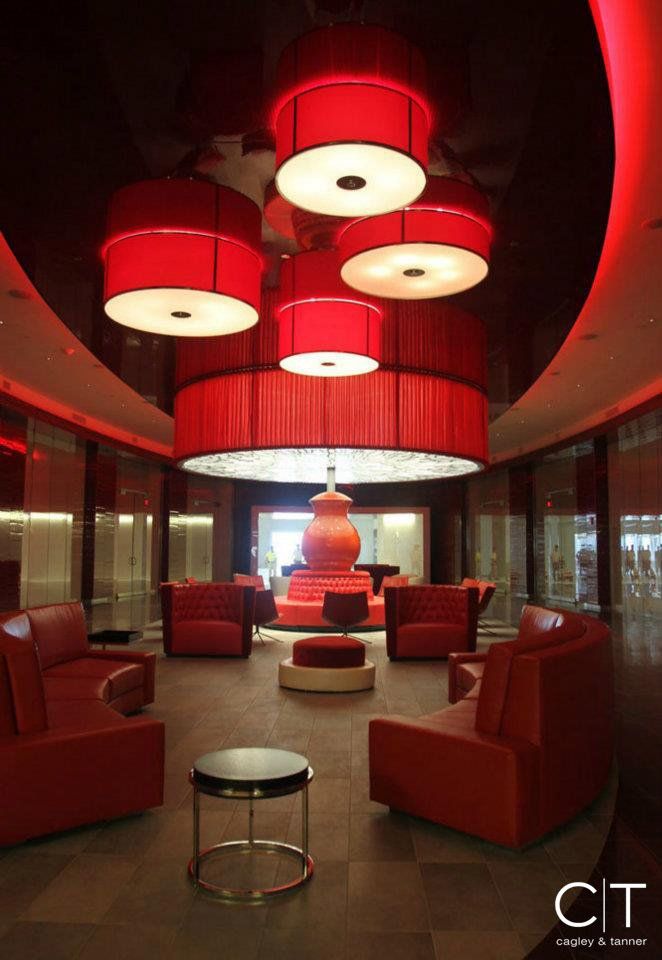 A living room with red furniture and a large red chandelier