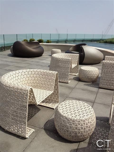 A patio with wicker chairs and ottomans with the word cit on the bottom