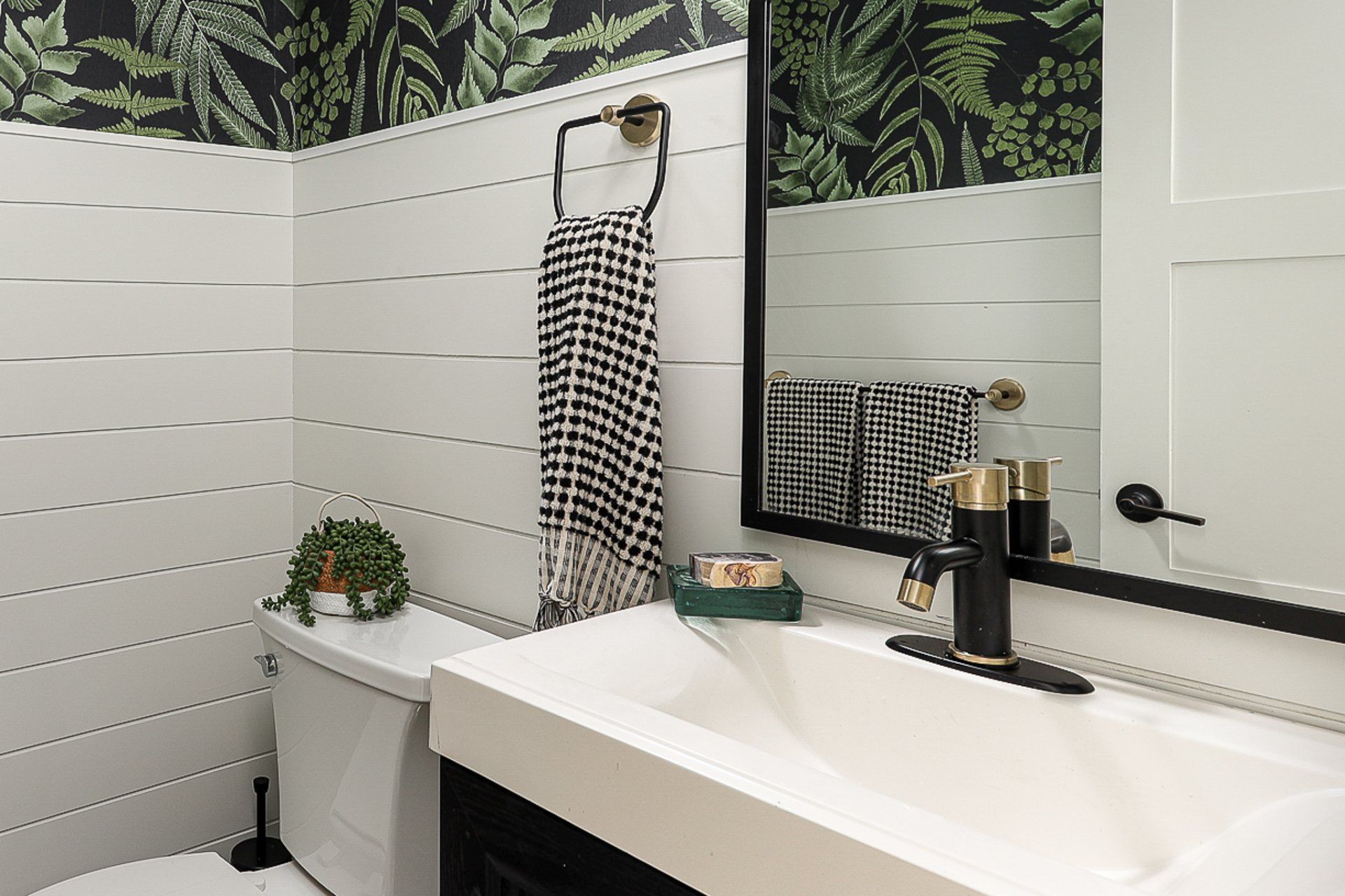 A bathroom with a sink , toilet and mirror.