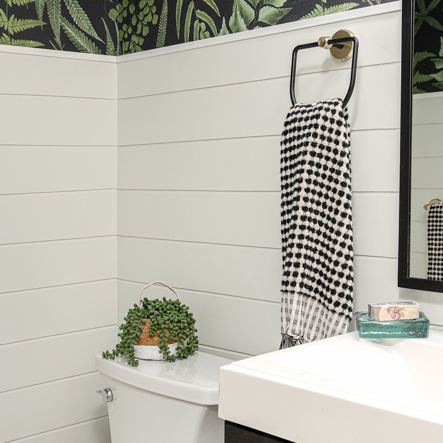 A bathroom with a toilet a sink and a mirror