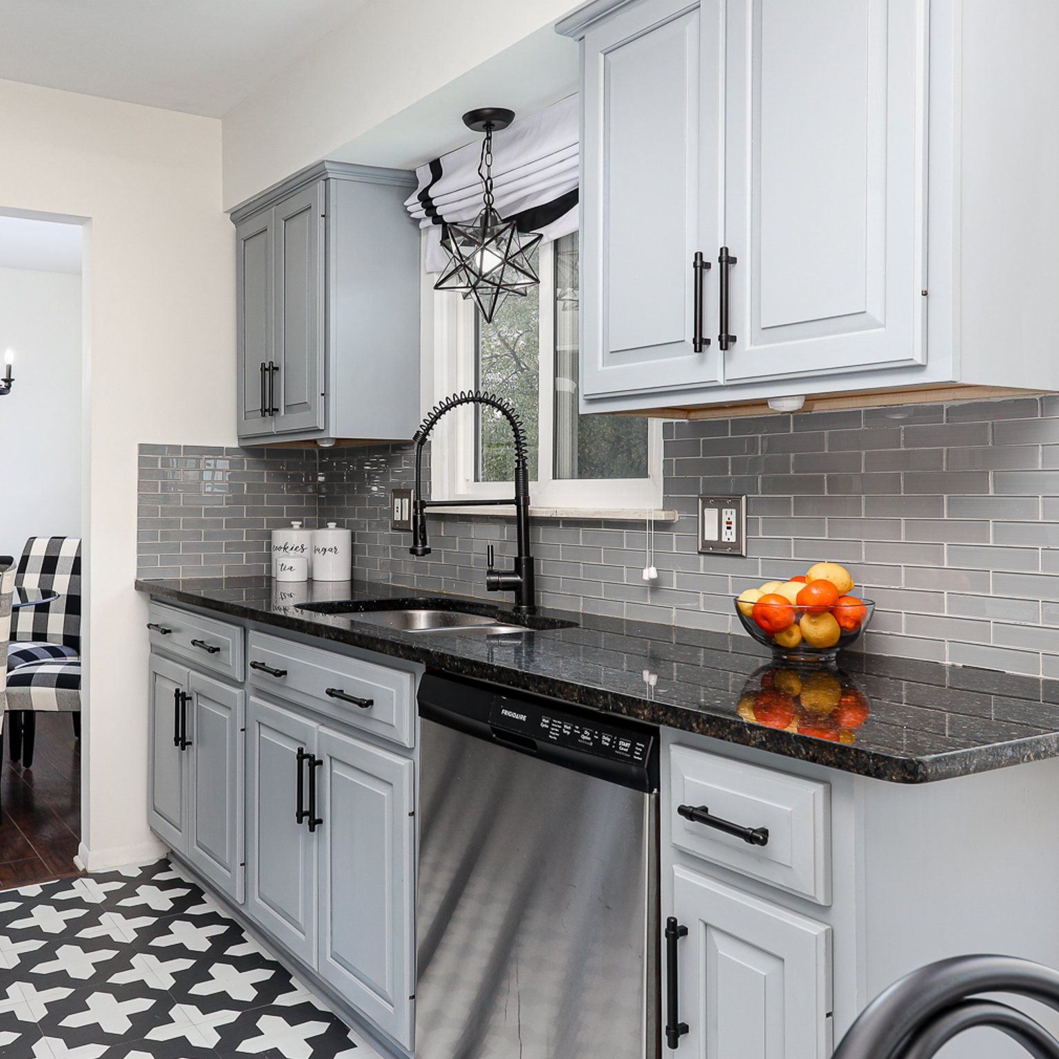 A kitchen with gray cabinets and a stainless steel dishwasher