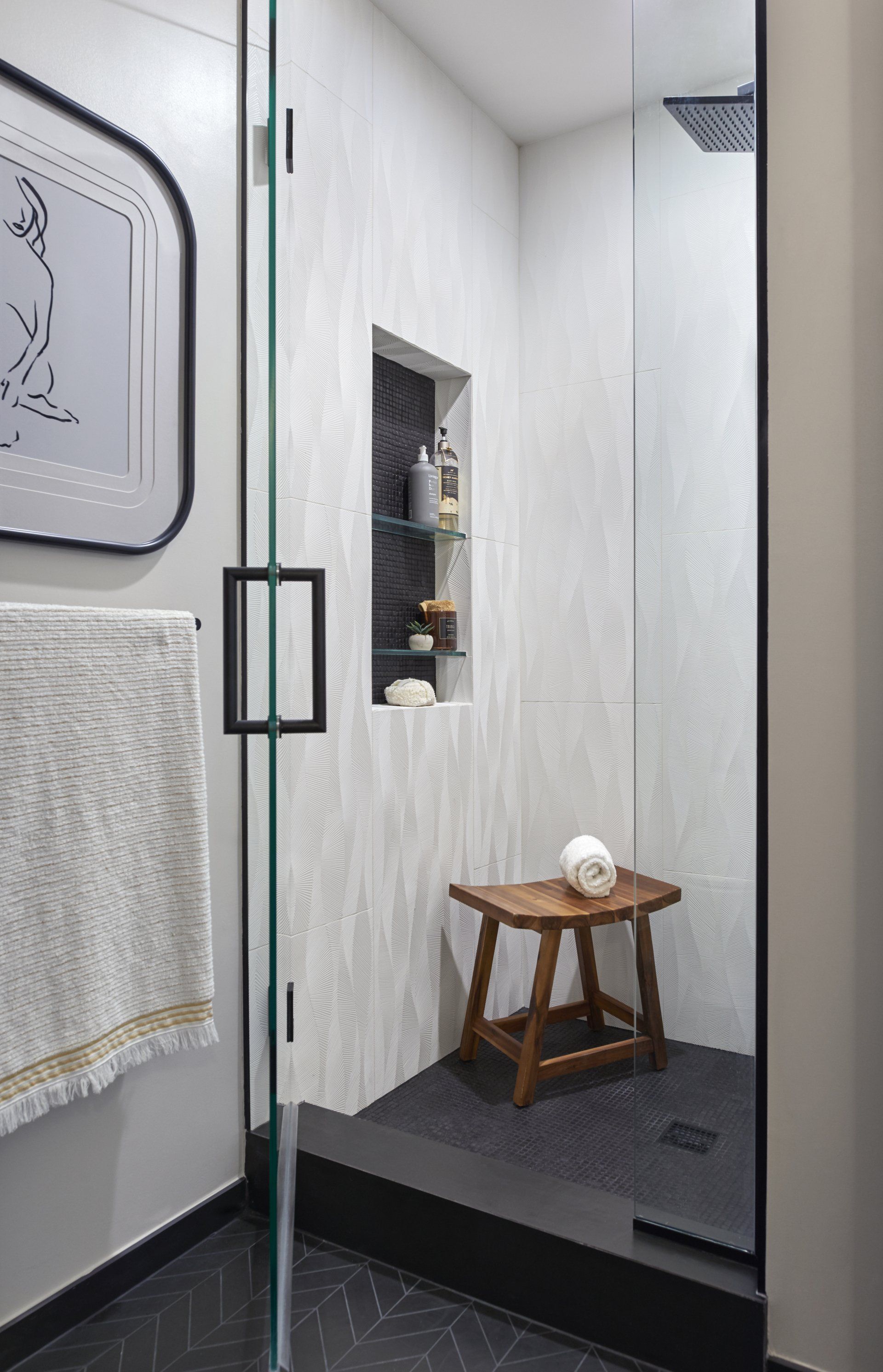 A bathroom with a shower and a wooden stool in it.