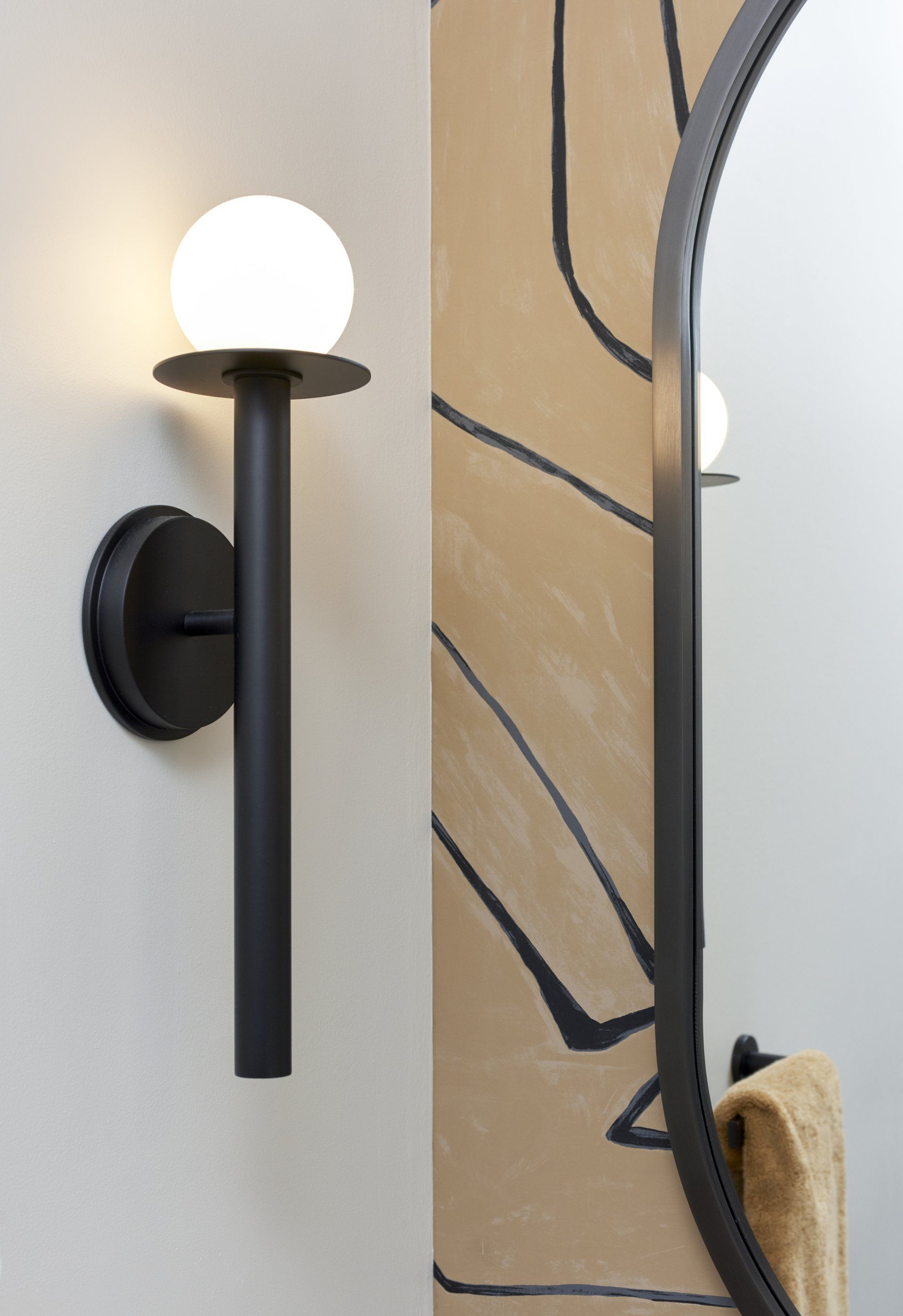 A bathroom with a wall light and a mirror.