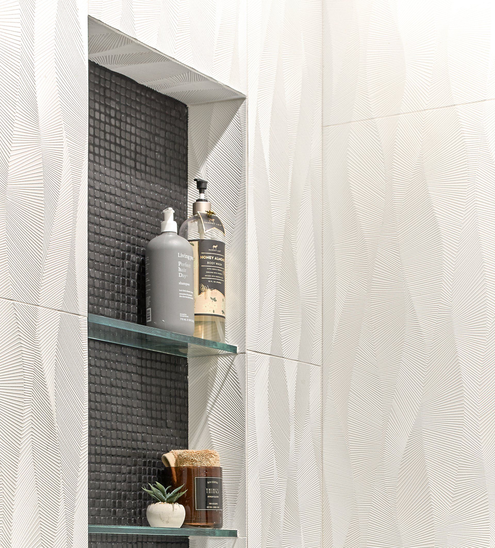 A bathroom with a shelf and a bottle of shampoo on it.