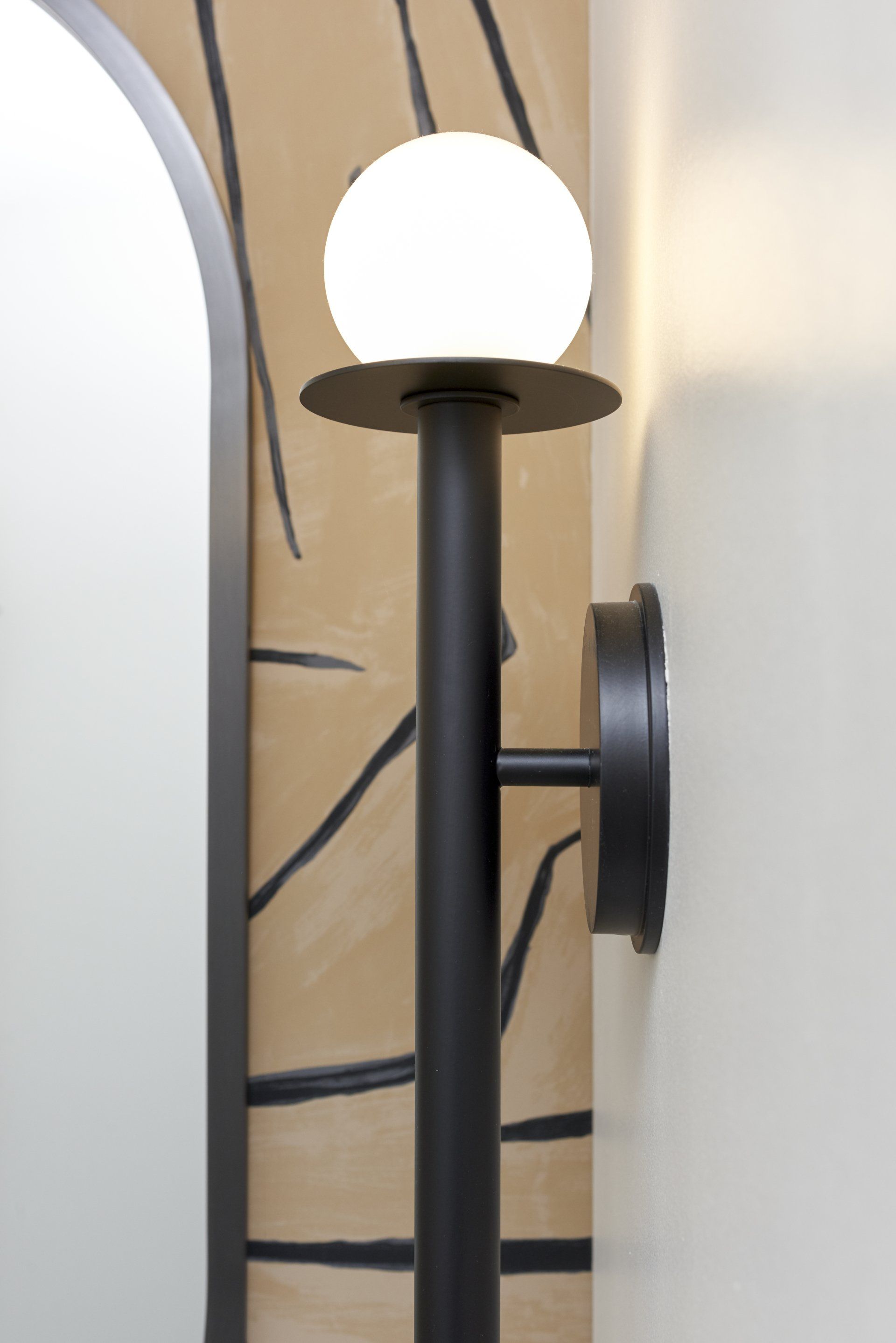 A black lamp with a white ball on top of it