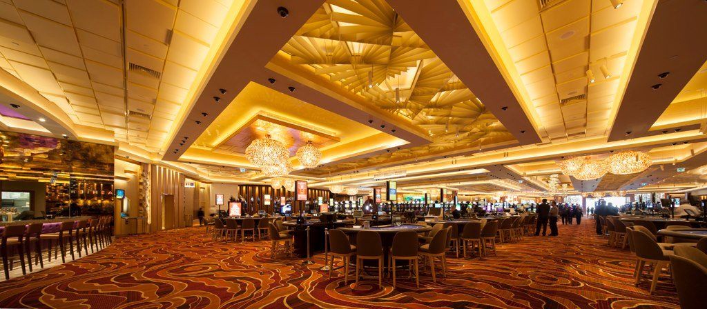 A large room with tables and chairs in a casino.