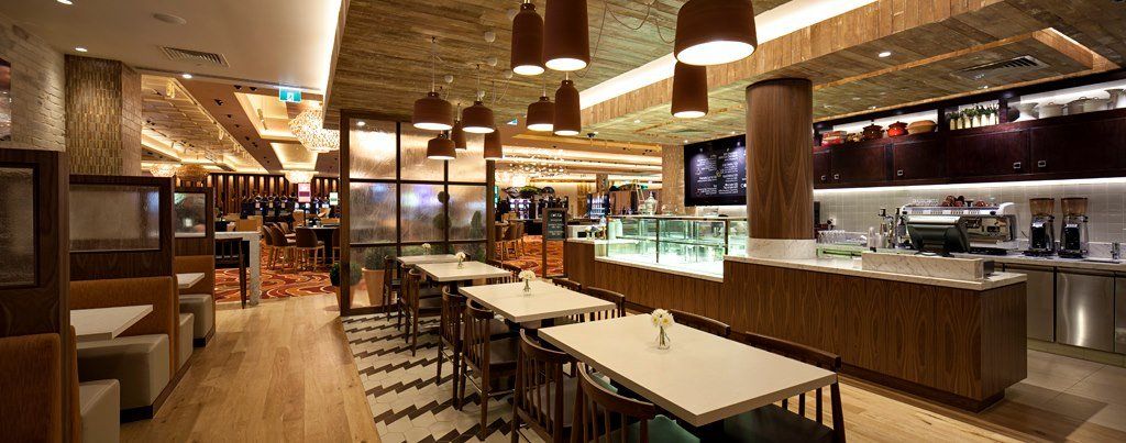 A restaurant with tables and chairs in a large room.