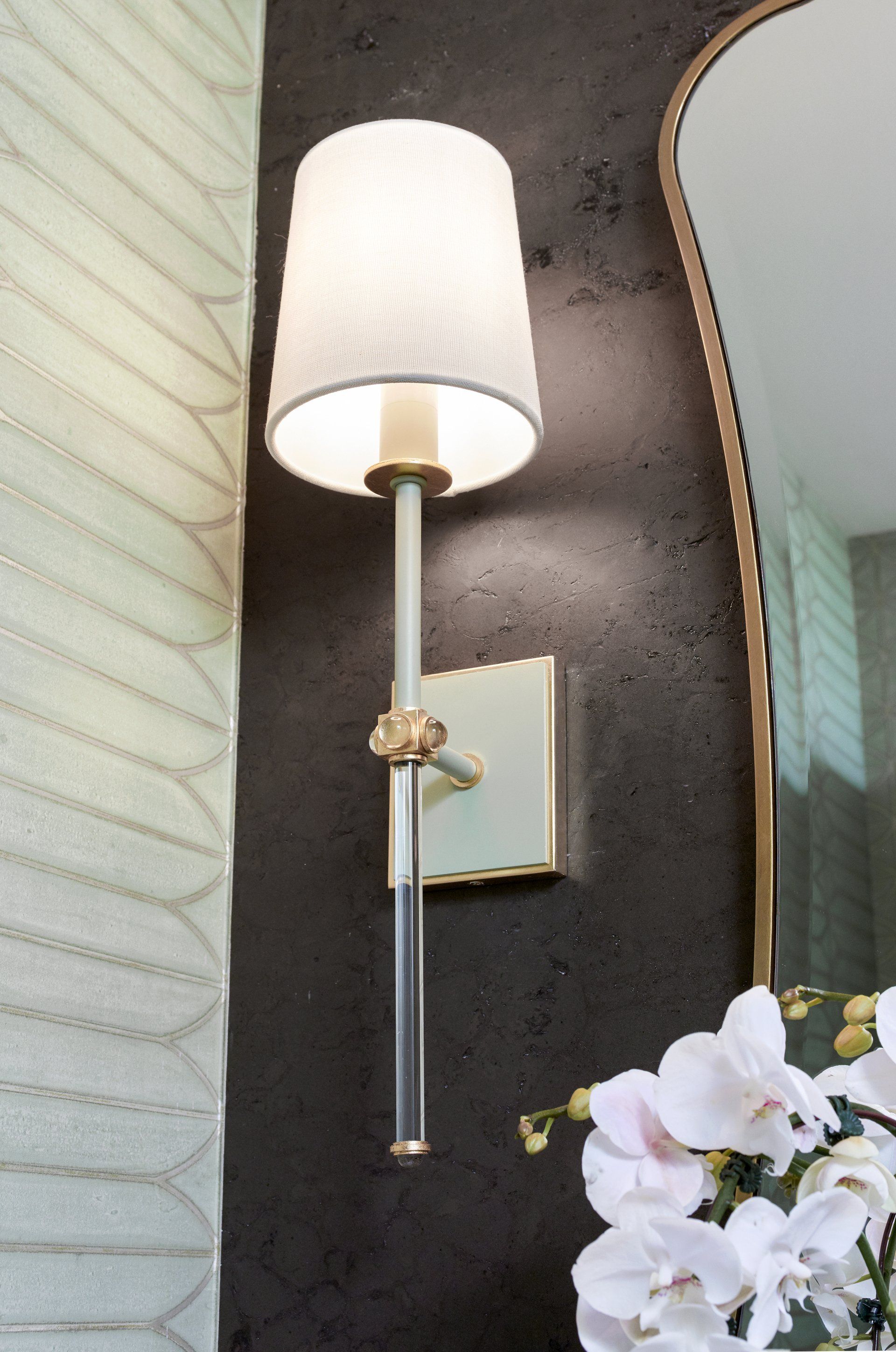 A lamp is hanging on a wall next to a mirror