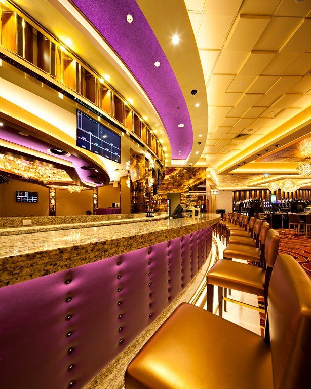 A long bar in a casino with purple walls