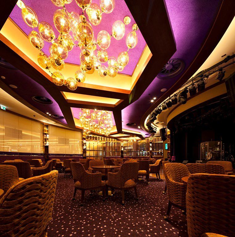 A large room with tables and chairs and a purple ceiling