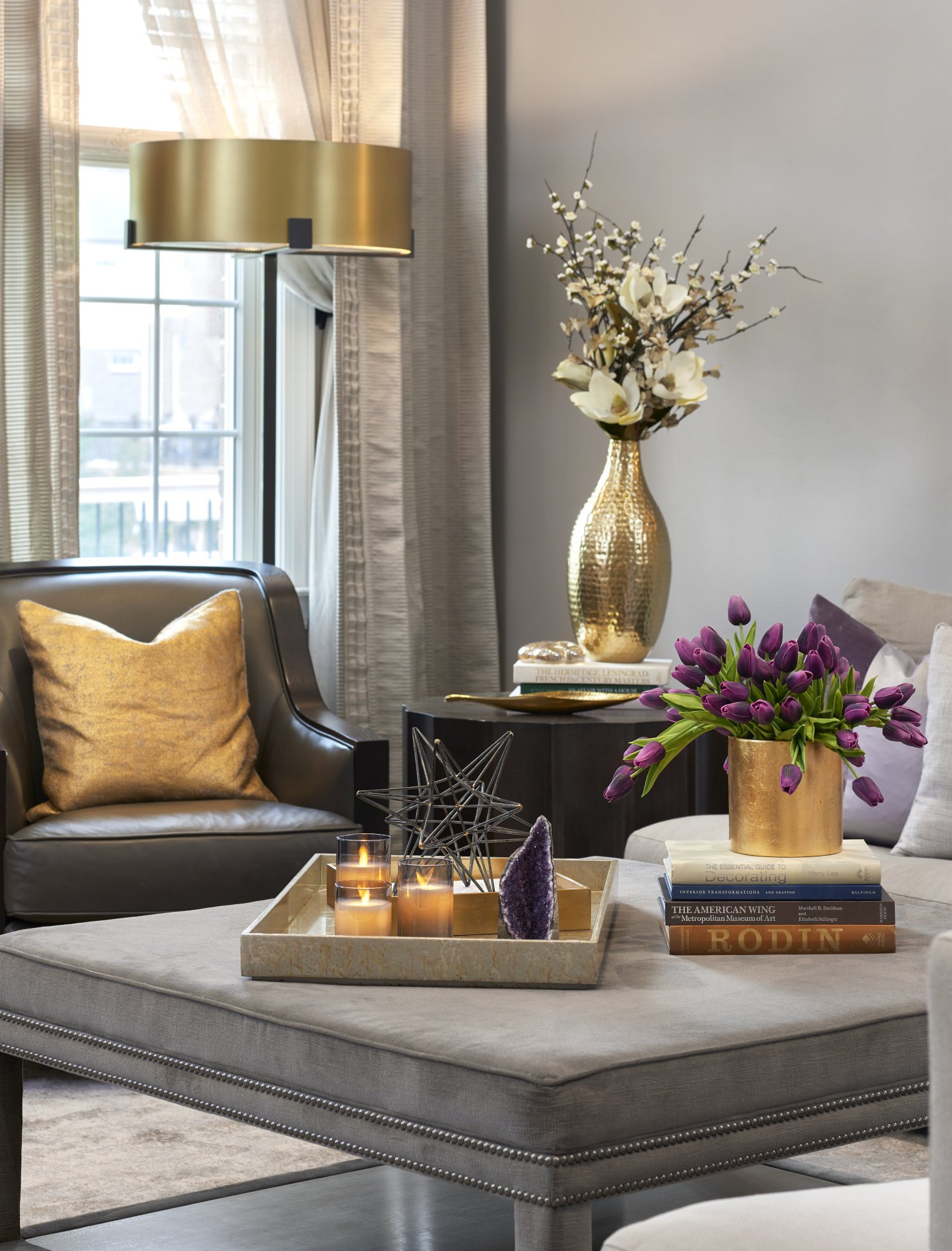 A living room with a couch a chair a coffee table and a vase of flowers