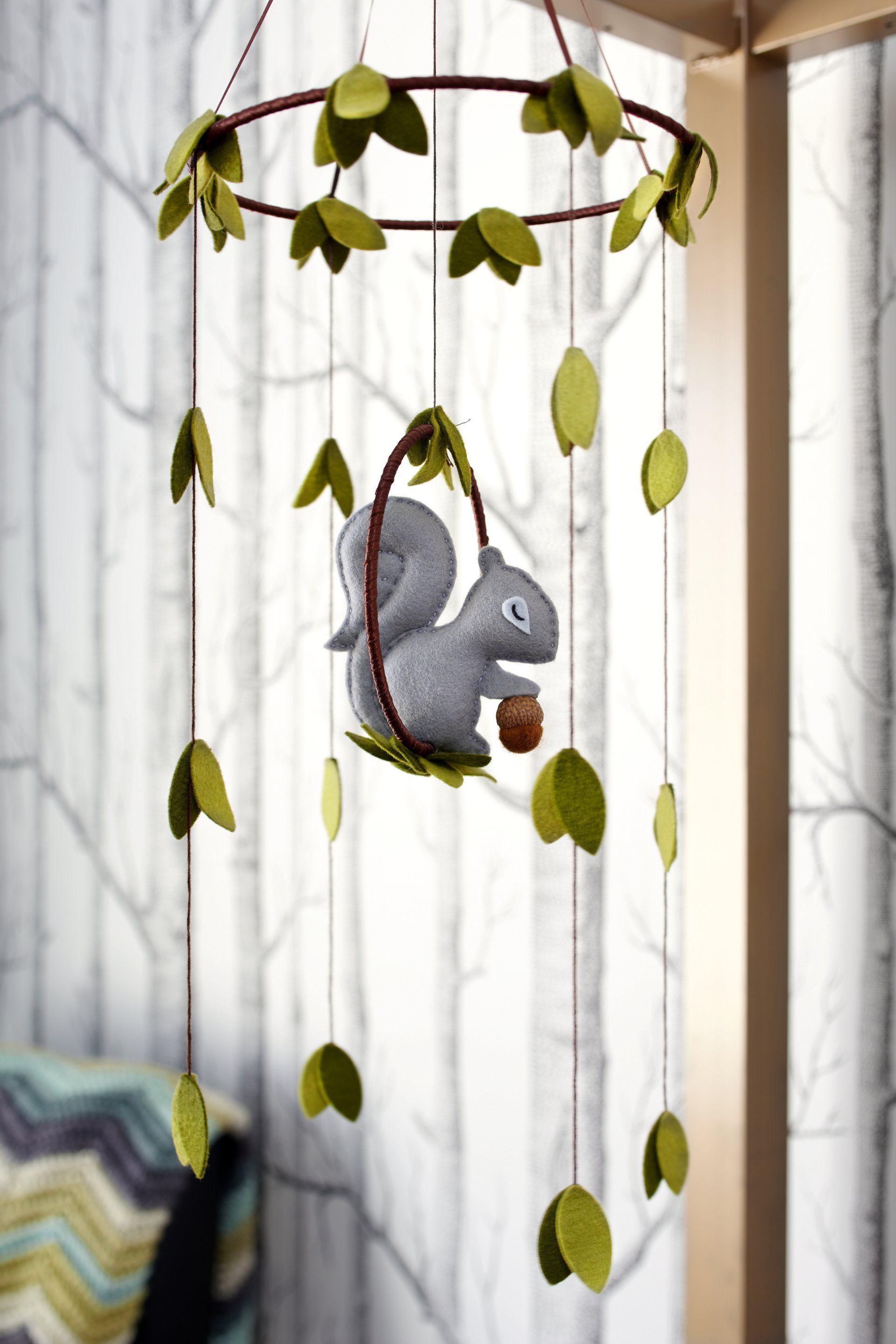 A baby mobile with a squirrel hanging from it