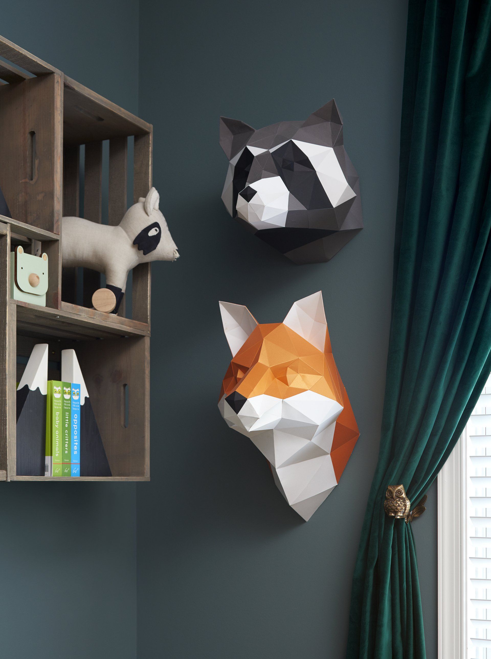 Three paper animals heads are hanging on a wall in a room.