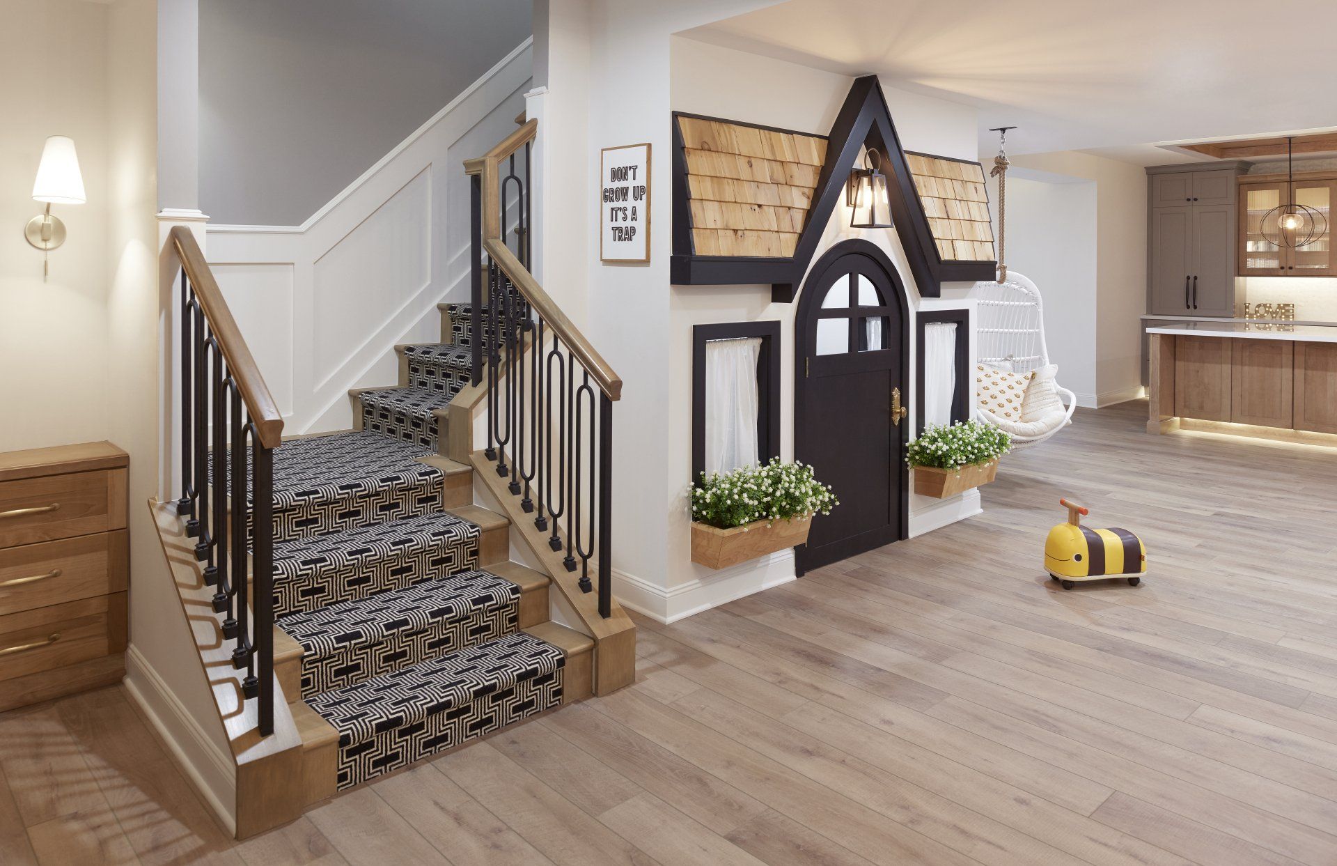 A basement with stairs and a playhouse built into the wall.