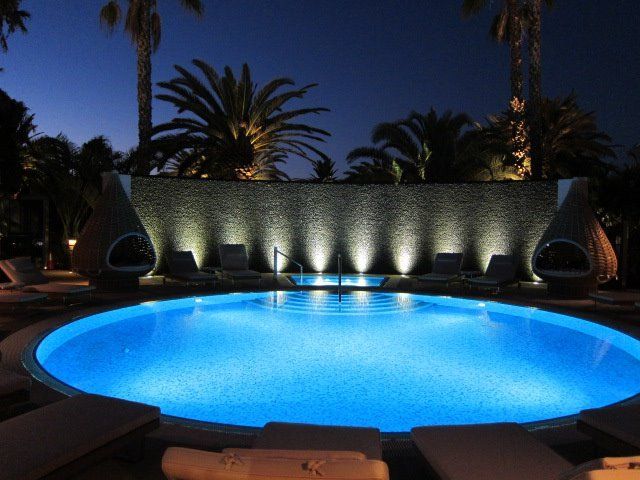 A large swimming pool is lit up at night