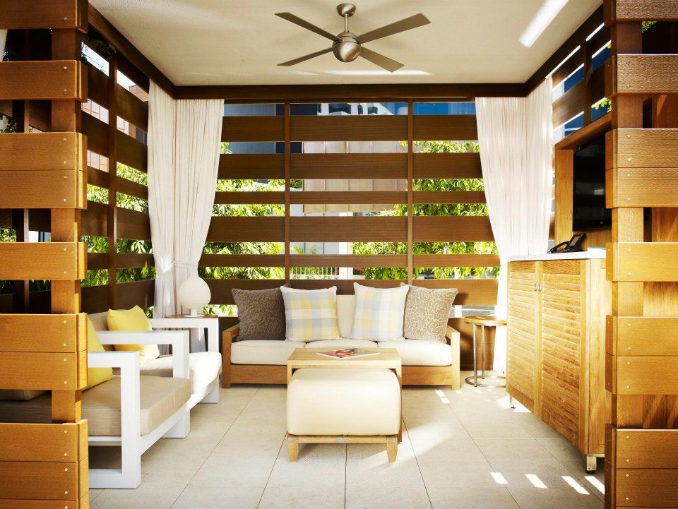 A living room with a couch and chairs and a ceiling fan