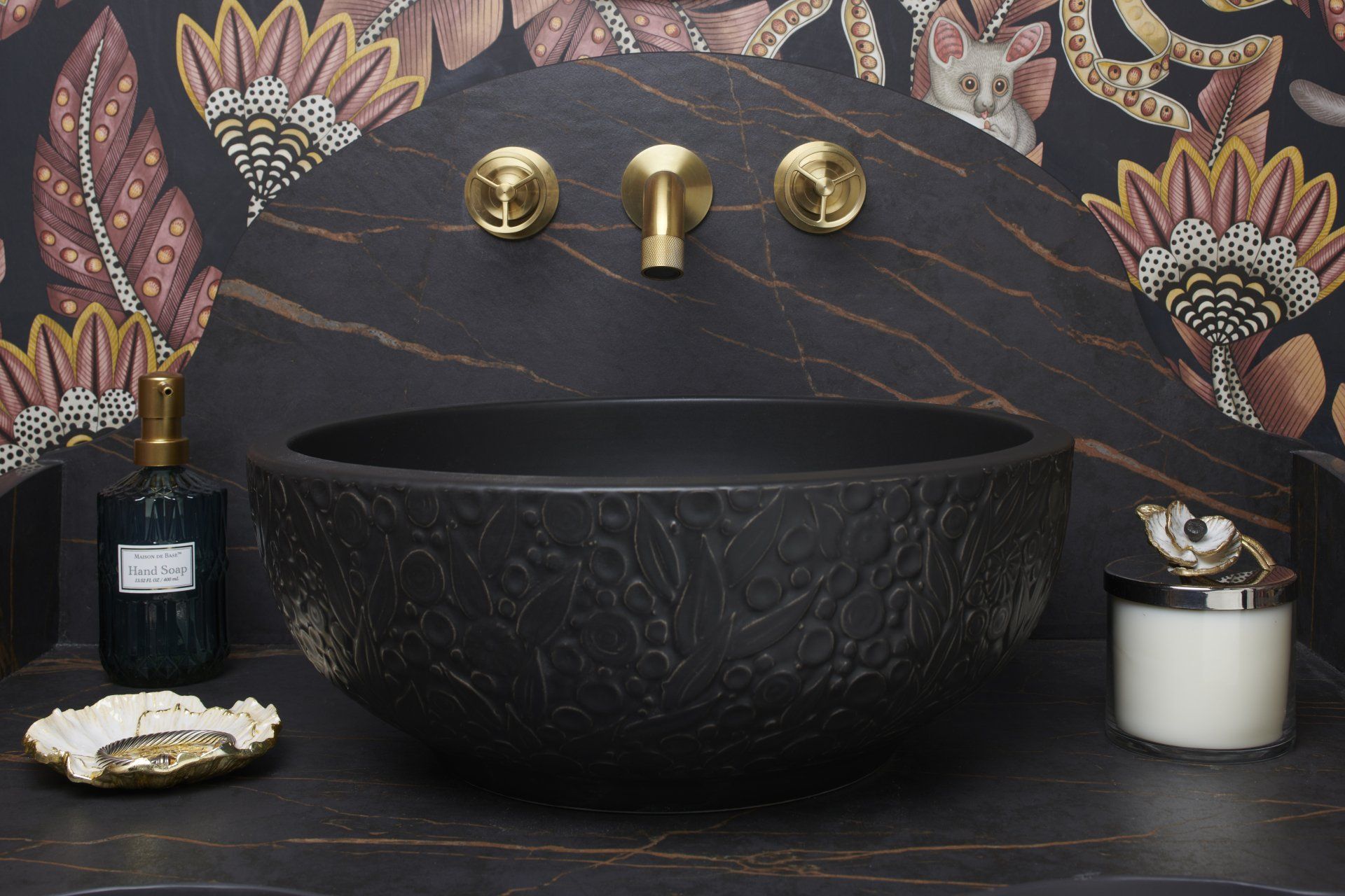 A bathroom with a black sink and a candle on the counter