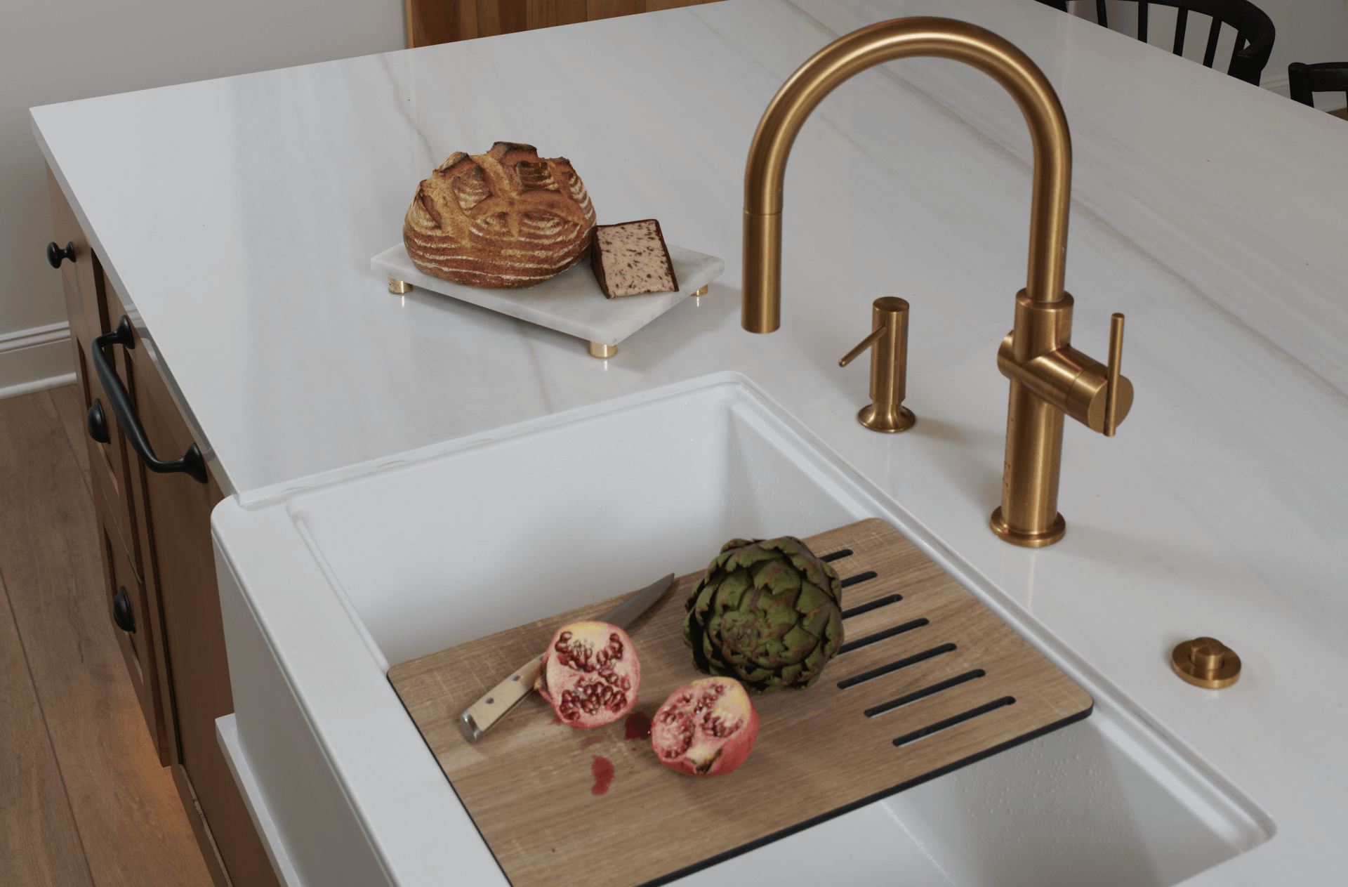 A kitchen sink with a cutting board and artichokes in it.
