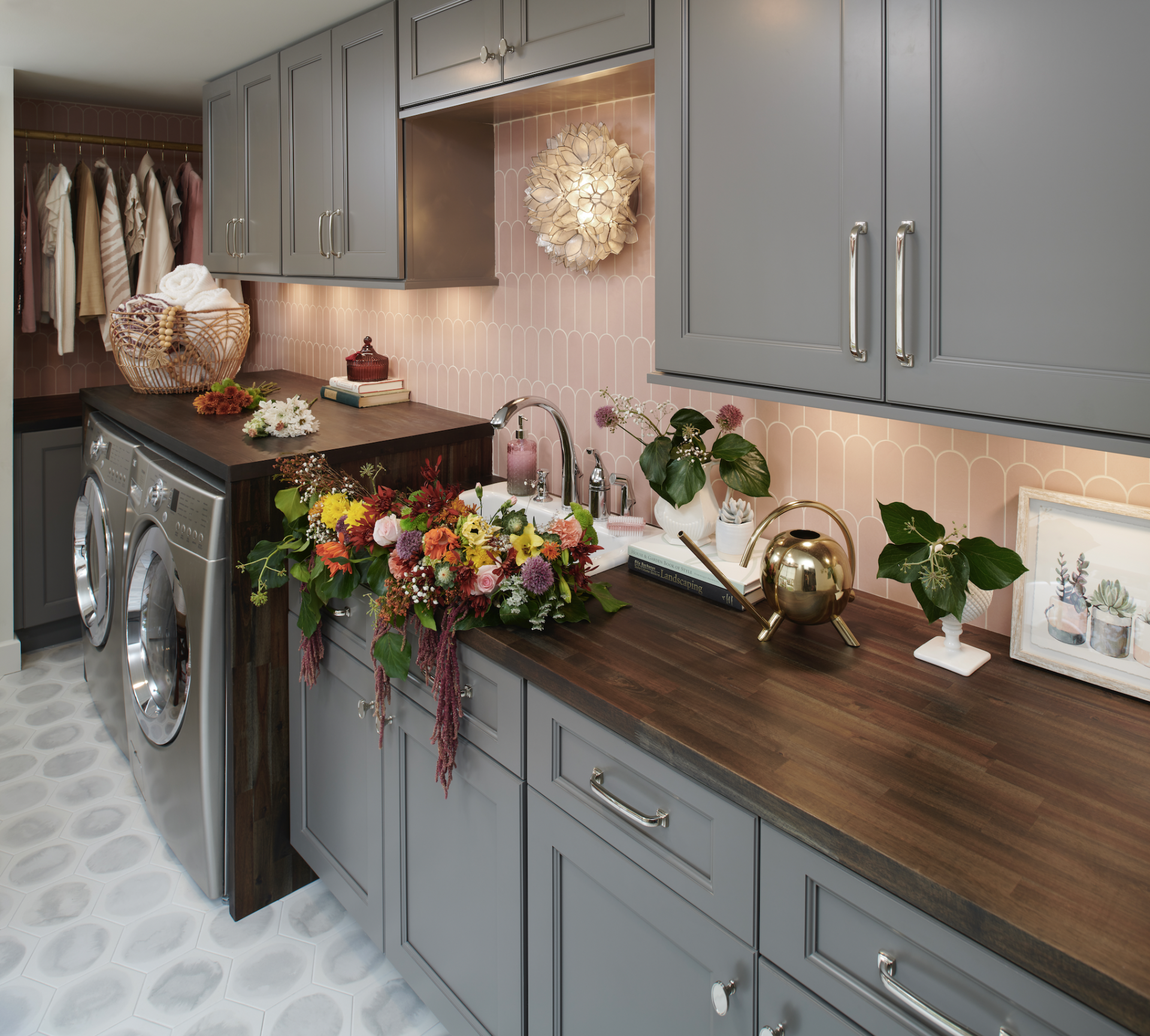A laundry room with gray cabinets and wooden counter tops