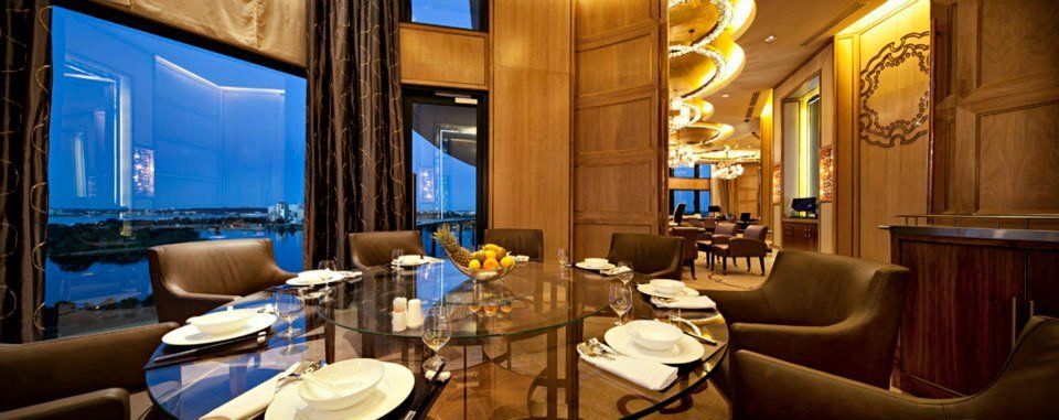 A dining room with a table and chairs and a large window.