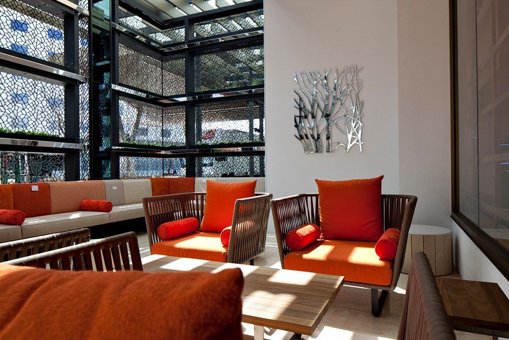 A living room with orange chairs and a couch