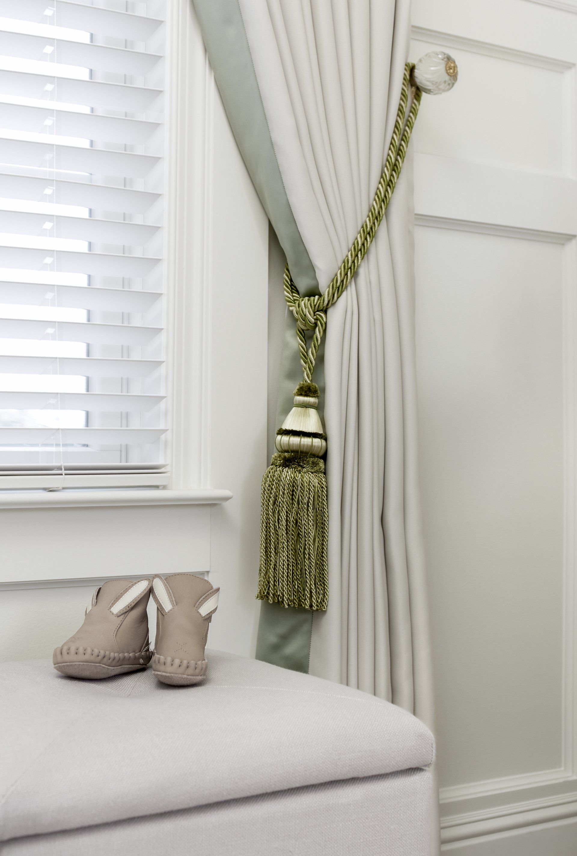 A pair of baby shoes are sitting on a bench next to a window.