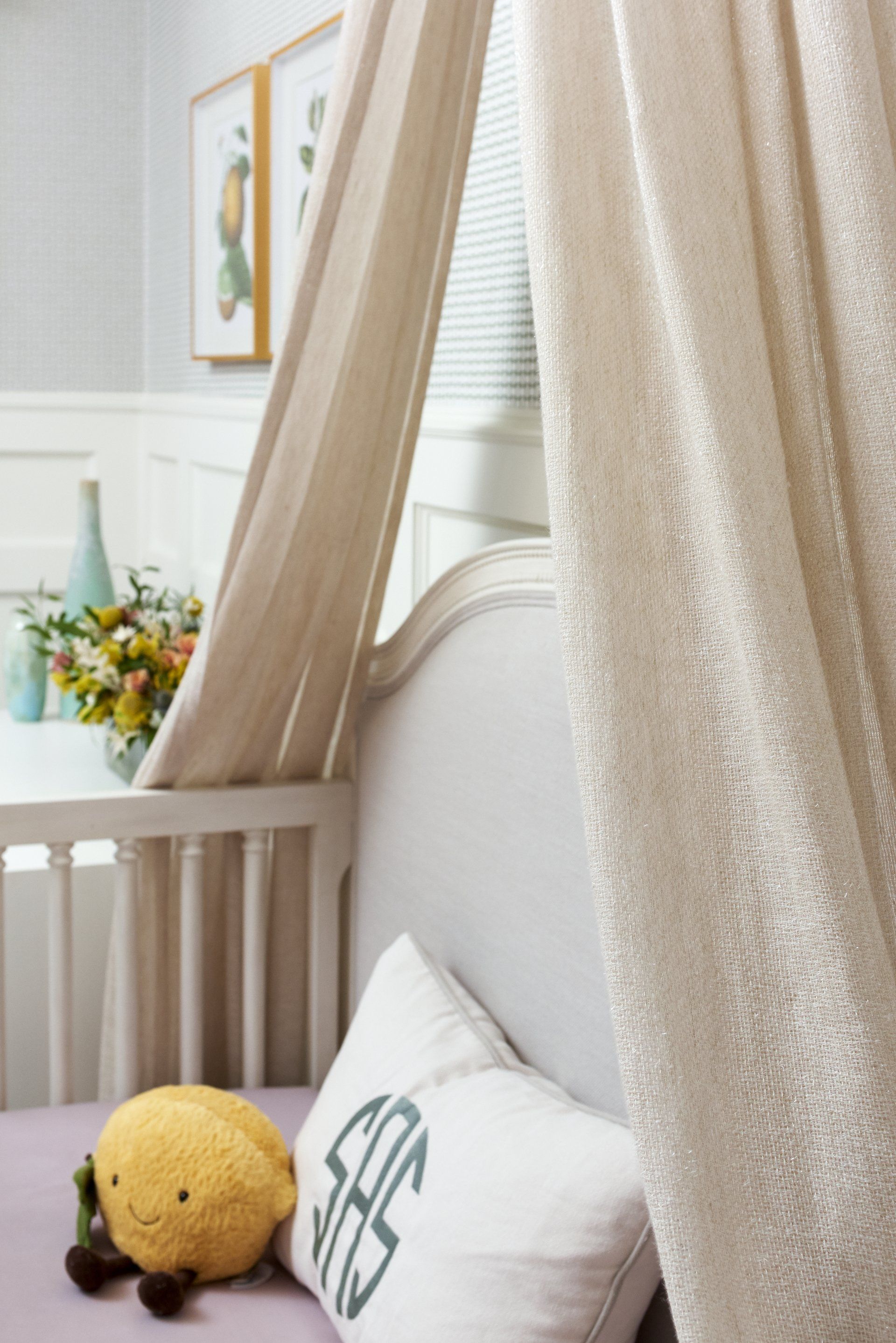 A crib with a canopy and a pillow with a monogram on it