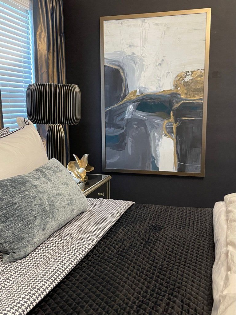 There is a painting on the wall above the bed in the bedroom.