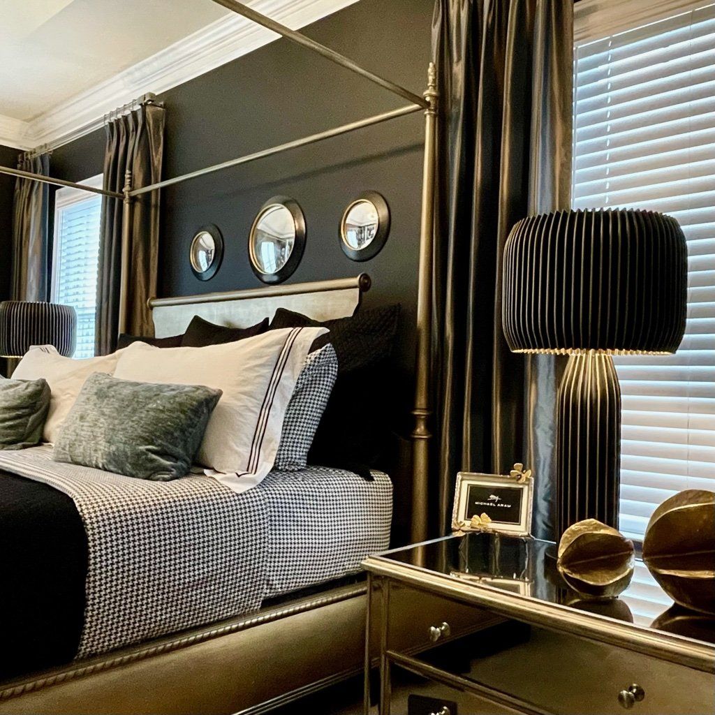 A bedroom with a canopy bed and a lamp