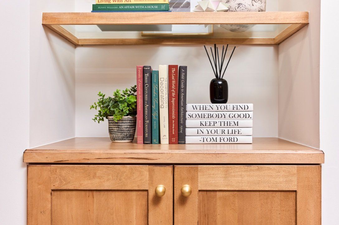 A stack of books sitting on top of a wooden shelf.