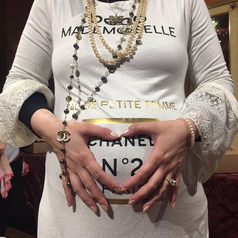 A woman wearing a white shirt that says chanel no 2