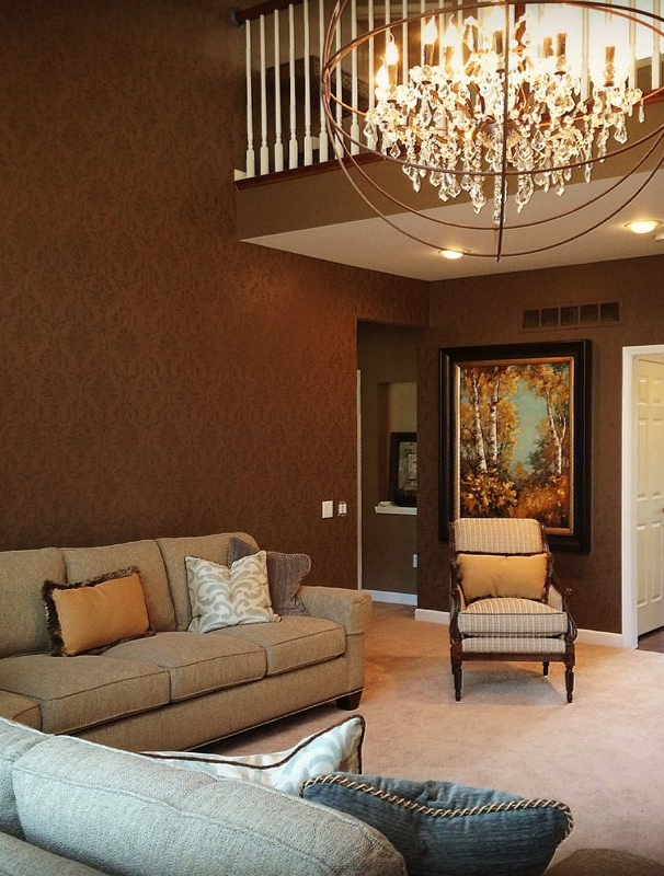 A living room with a couch a chair and a chandelier