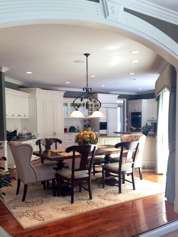A dining room with a table and chairs and a rug