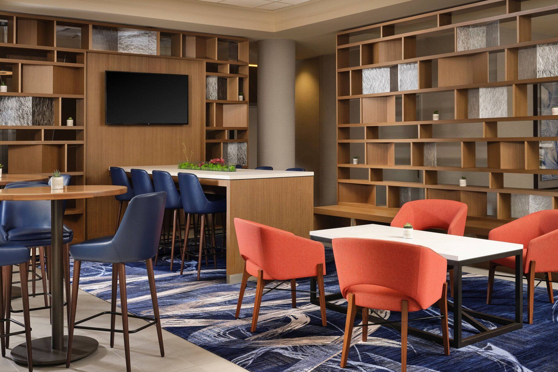 A living room with tables and chairs and a flat screen tv.