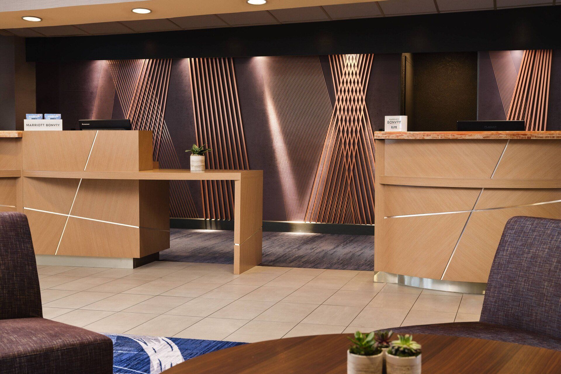 A hotel lobby with a wooden table and chairs